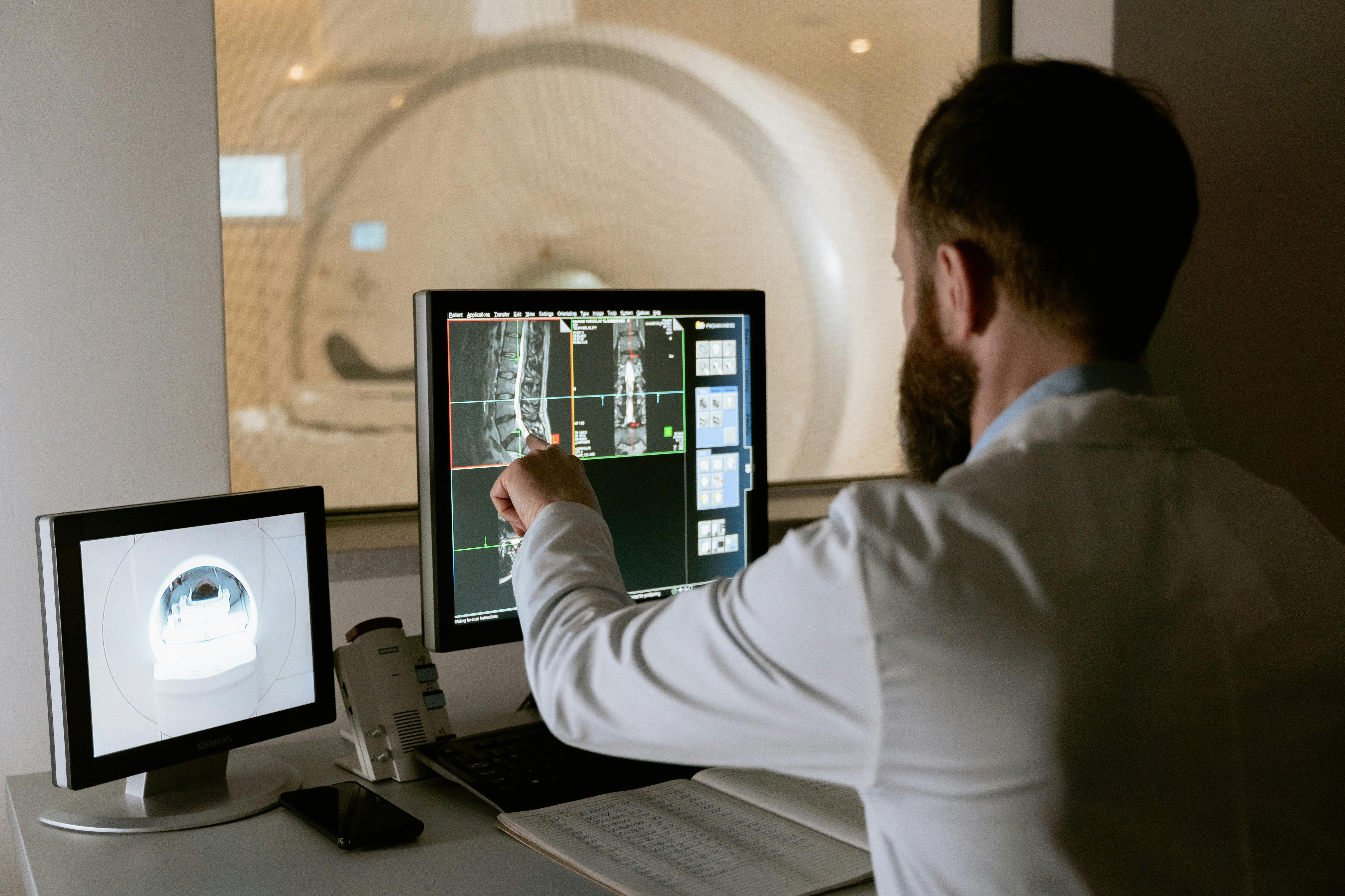 Radiologist reviewing medical imaging scans at a workstation